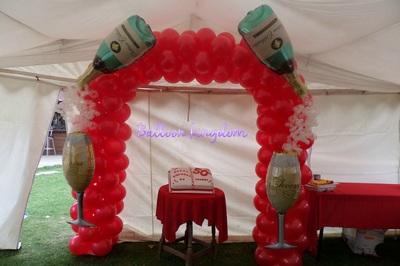 Balloon arch with foil balloon champagne bottles, glasses and bubbles