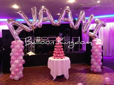light pink, white and silver balloon columns with name arch