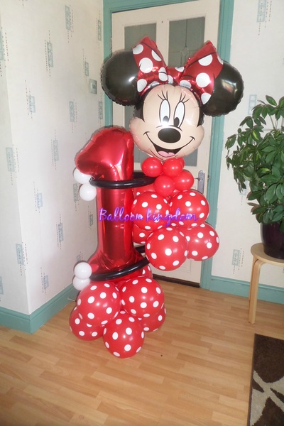 red minnie mouse holding a large number  balloon sculpture 
