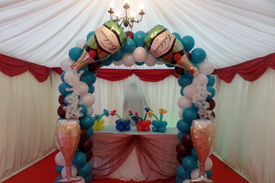Balloon arch with foil balloon champagne bottles, glasses and bubbles
