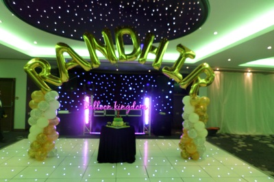 jungle themed spiral columns with name balloon arch at riverside venue