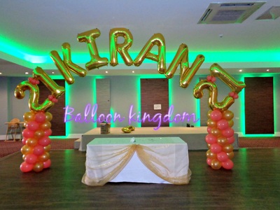 coral and gold balloon columns with name arch